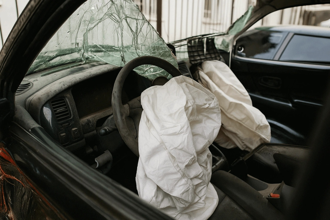a car with broken glass and deployed airbags