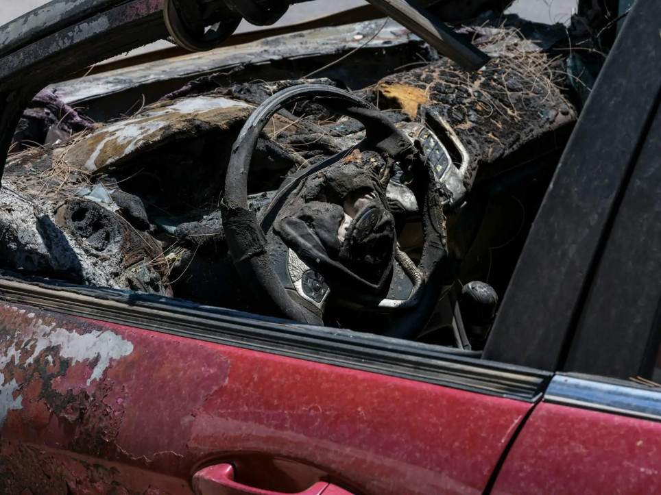 damaged car interior with broken glass and burnt steering wheel