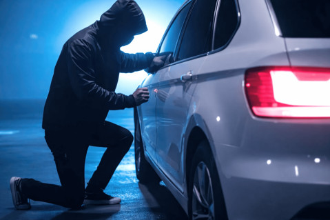 a thief is trying to open a parked car